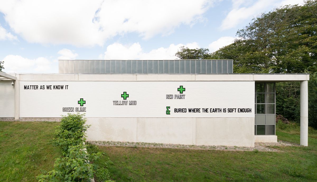 Lawrence Weiner, MATTER AS WE KNOW IT + RED PAINT + YELLOW MUD + GREEN SLIME & BURIED WHERE THE EARTH IS SOFT ENOUGH (1995). In the Museum garden. Photo: David Stjernholm, 2021